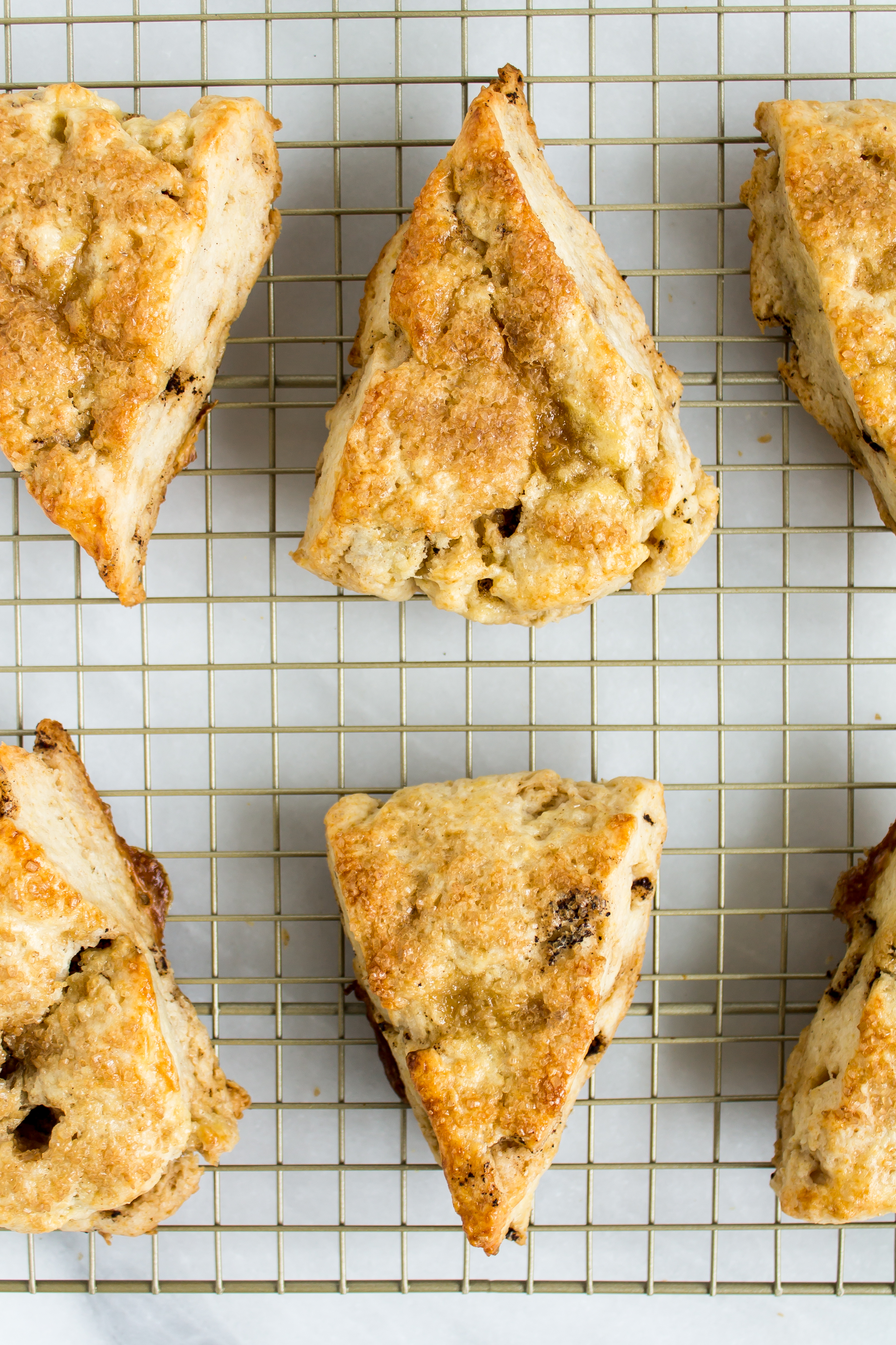 Brown butter scones with apple cider glaze capture the fall season in a pastry so perfectly. The nutty brown butter flavor paired with the sweet, classic apple cider makes for a delicious seasonal breakfast treat that will impress all of your guests. | www.passthecookies.com