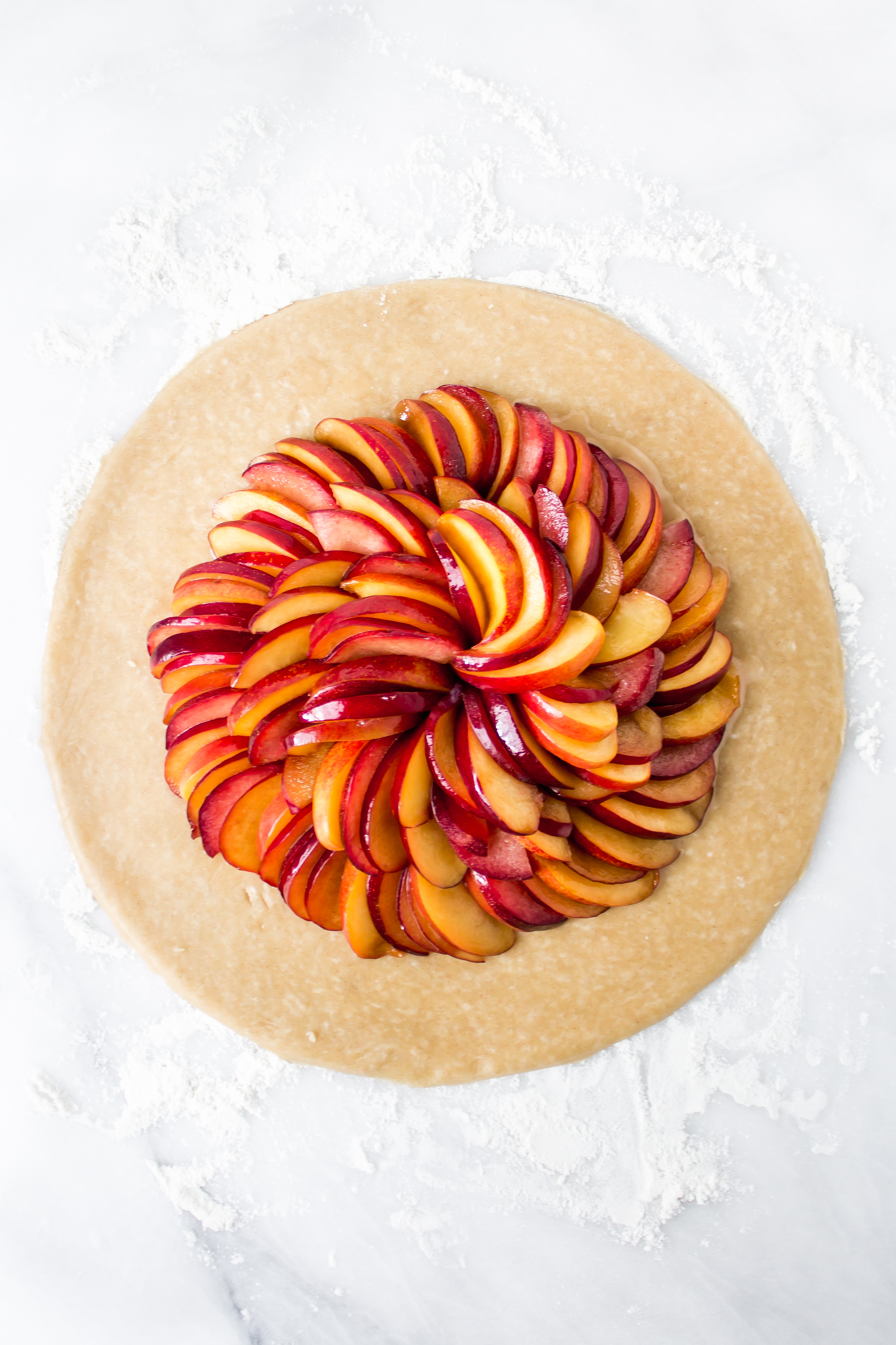 Easier than pie? This plum and peach galette with cinnamon whipped cream is an easy, but impressive and delicious end of summer dessert. | Pass the Cookies | www.passthecookies.com